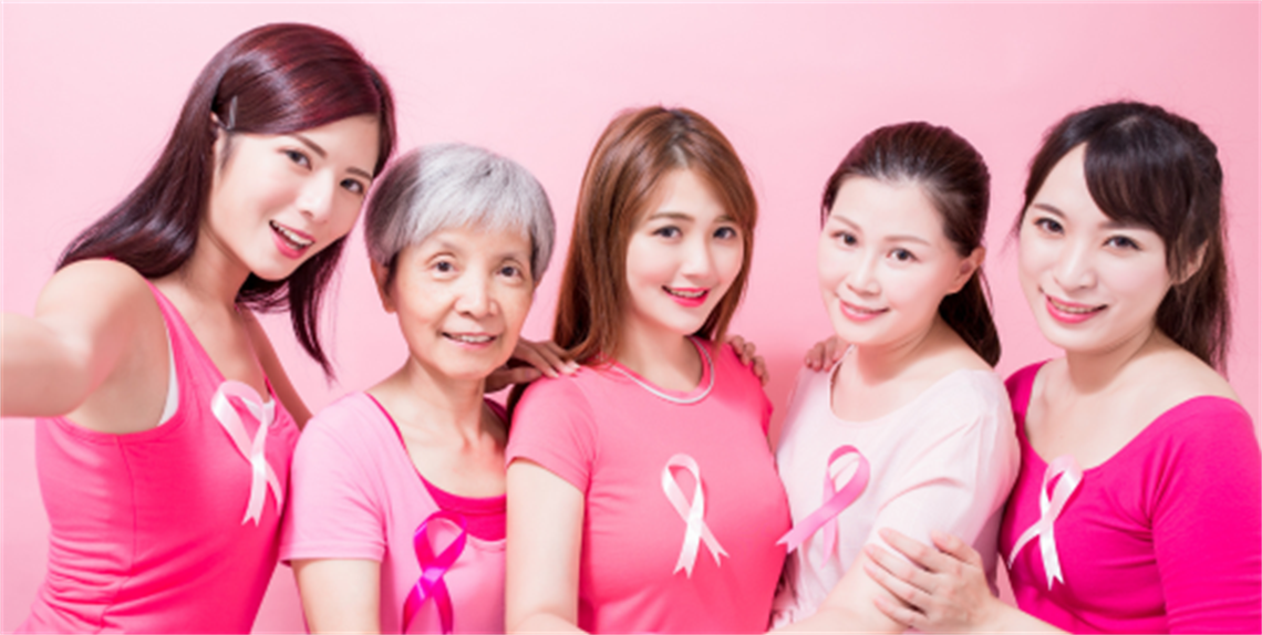 Asian women of various ages wearing pink shirts and ribbons