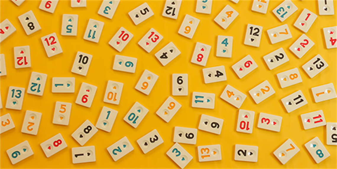 Rummikub pieces on yellow background