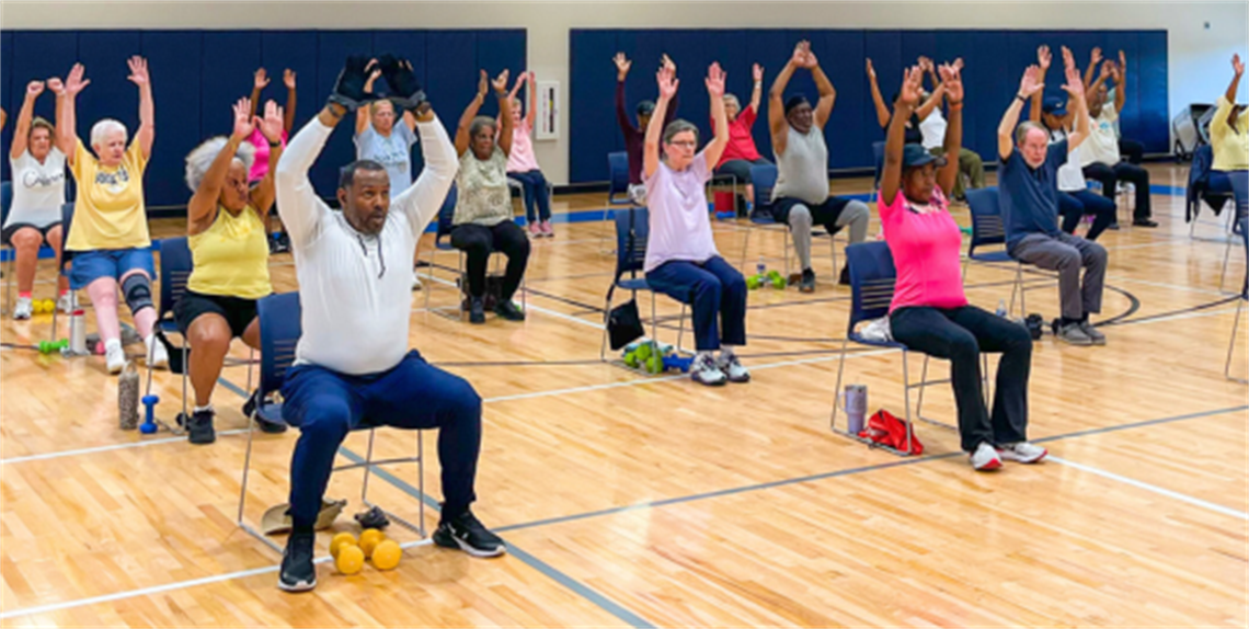 50+ Adults in chair fitness class in a gym