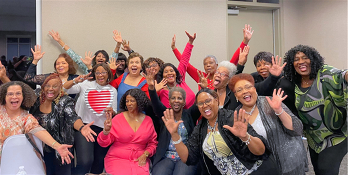 Large group of ladies waving at the camera