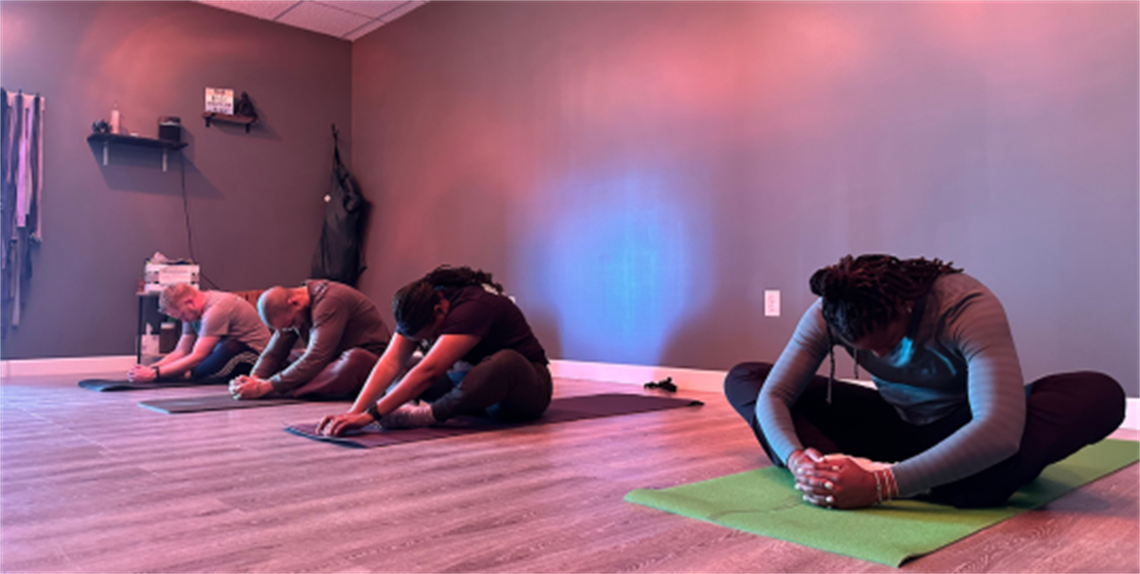 Several people on the floor doing Yoga Pilates