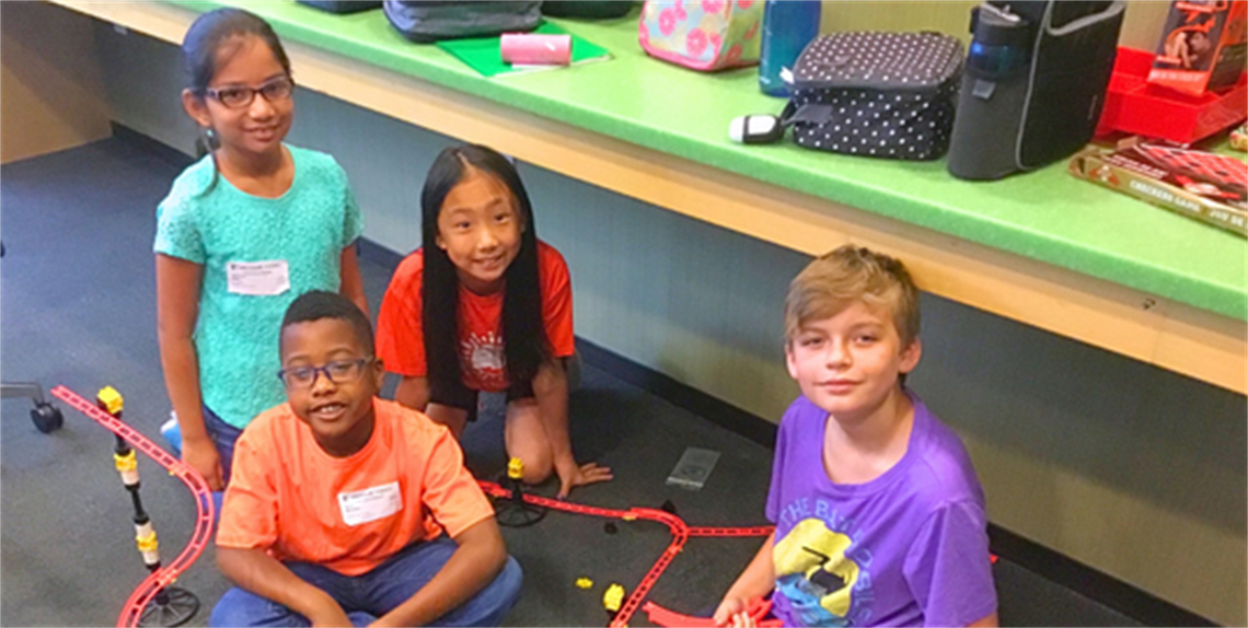 Group of kids on the floor with a STEAM project