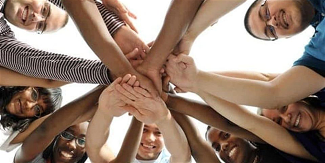 Group of diverse kids with their hands together in a ring